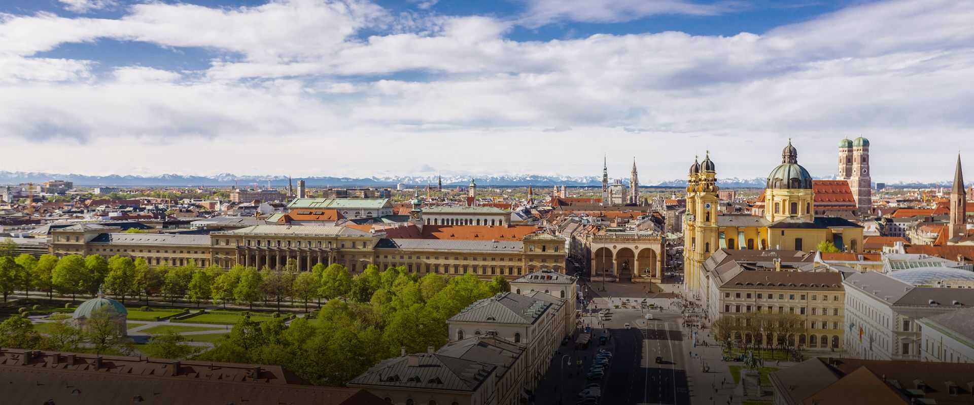 Skyline von München mit Immobilien und Bergen im Hintergrund