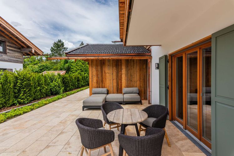 Großzügige Terrassenfläche zum Kauf mit Lounge- und Essbereich von Erdgeschoss-Wohnung in Rottach-Egern am Tegernsee mit Bergblick.
