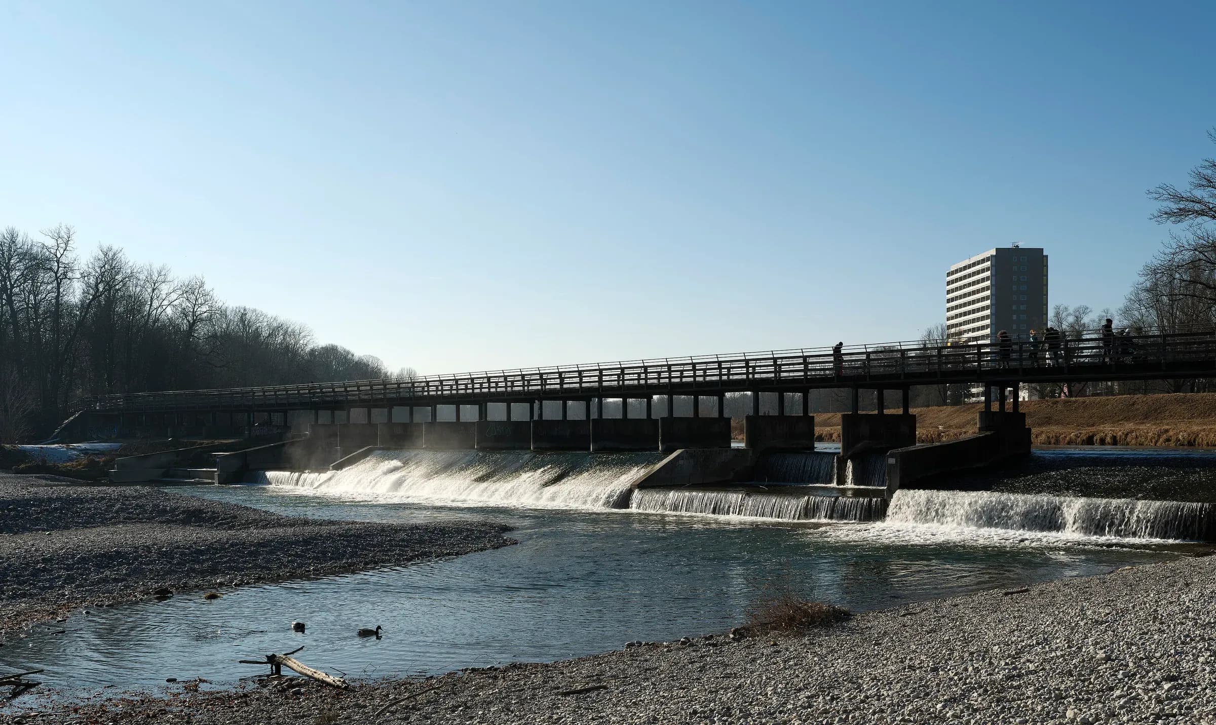 Die Isar mit Wehr und Kiesbank am Flaucher – sinnbildlich für die Isarlage von Untergiesing-Harlaching